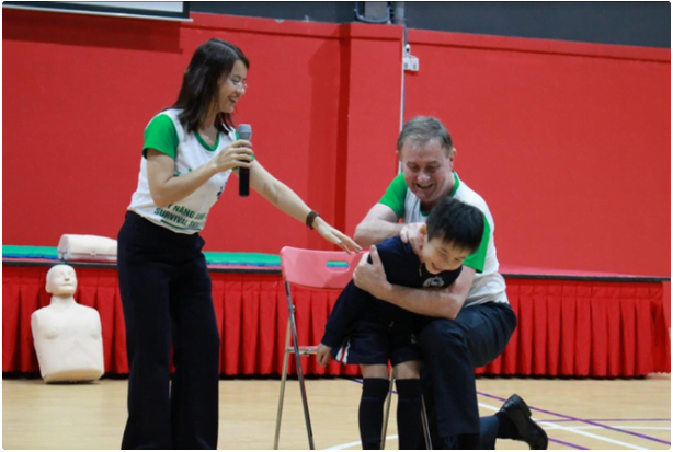 Mr. Tony Coffey and Ms. Trang Jena Nguyen practice first aid for victims of food choking. (Photo: Ngoc Trang)